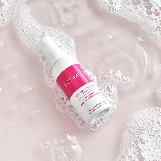 Intimina cleaner spray - white and pink bottle in soapy water