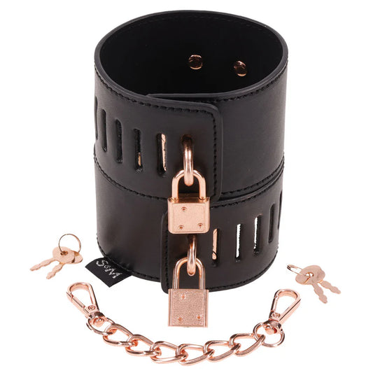two black leather cuffs with rose gold locks, keys and chain