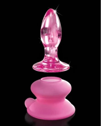 pink glass butt plug with silicone base underneath and black background