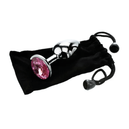 small metal butt plug with pink gem base on top of soft black storage bag