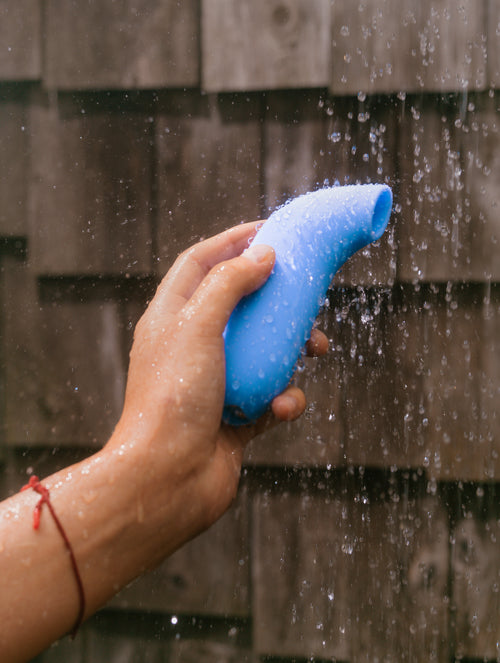 hand holding Aer vibrator under shower