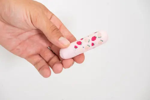 Hand holding Pink Bari Vibrator with strawberry print