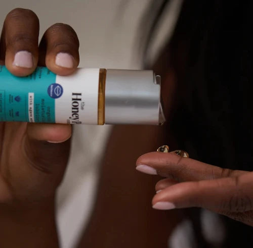 hands holding organic agave lube with a couple drops of lube on fingers