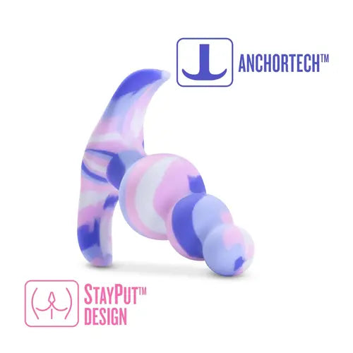 Colorful silicone butt plug on its side with words that say anchor tech and stay put design