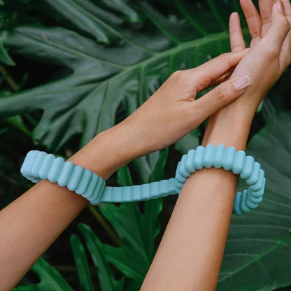 Biind cuffs around hands with leaves in background