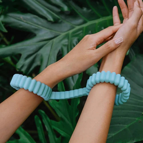 Biind cuffs around hands with leaves in background