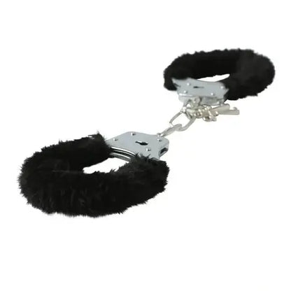 Black furry handcuffs with metal clasps against white background, side view