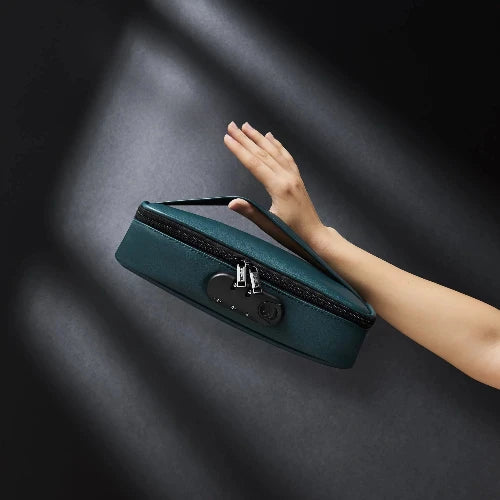hand holding luxury green discreet box against black background