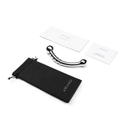 stainless steel bow massager next to soft storage bag and two white cards