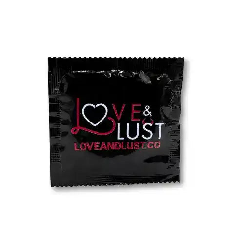 single condom in black wrapper that says love and lust against white background