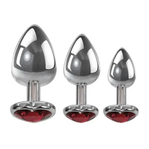 set of three metal butt plugs with red heart gem base against white background