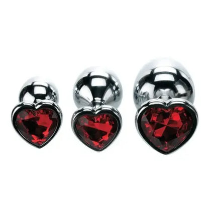 set of three metal butt plugs with red heart gem base against white background