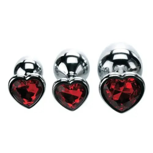 set of three metal butt plugs with red heart gem base against white background