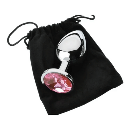 metal butt plug with pink gem base on top of black storage bag