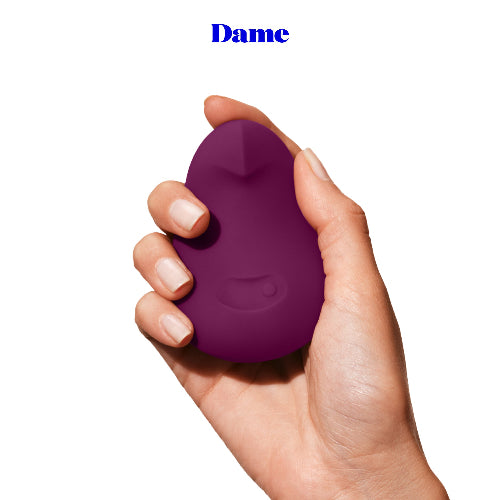 Hand holding Dame Plum Pom 