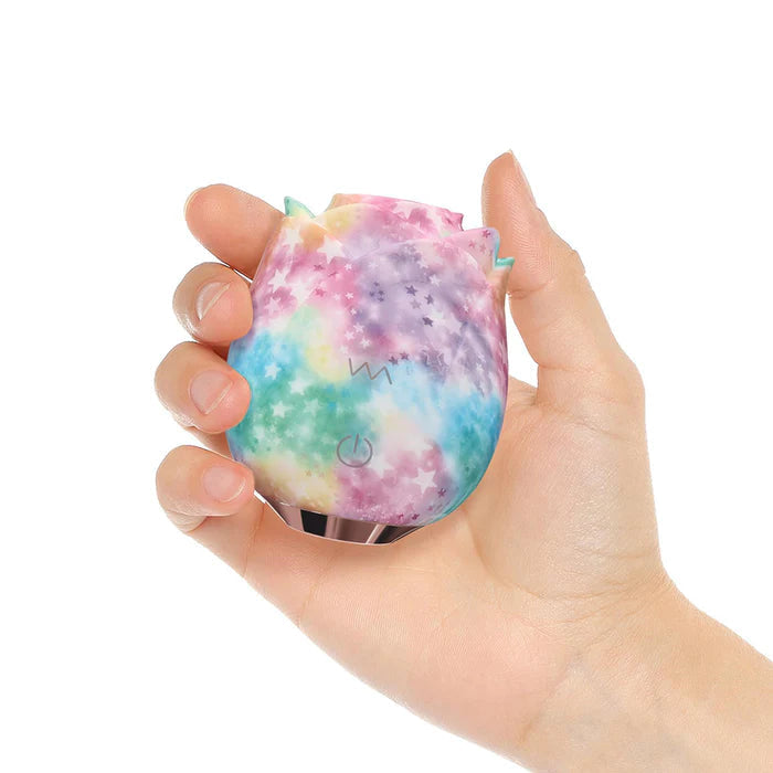 Hand holding Rainbow rose toy against white background