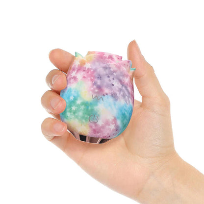 Hand holding Rainbow rose toy against white background