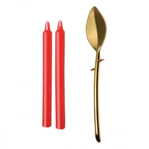 two red candles and gold spoon